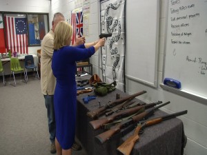 Reporter Lena Howland of KRDO handles guns in a Colorado City middle school.